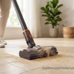 Aspirador de pó vertical aspirando areia fina em piso de porcelanato claro